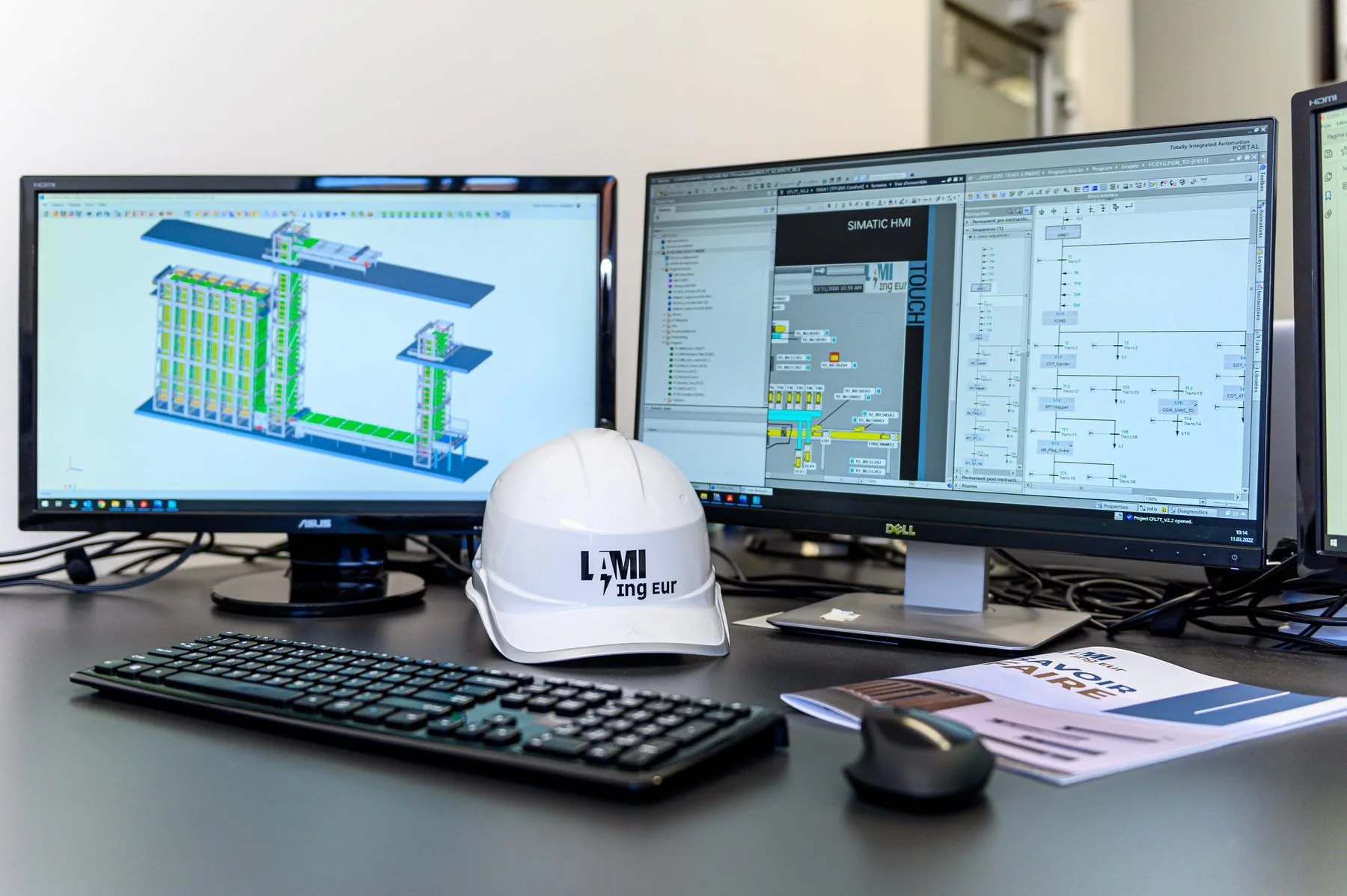 Engineering technical drawings on screen with a Lami Ing Eur branded hard hat